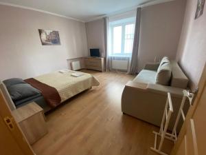 - une petite chambre avec un lit et un canapé dans l'établissement Апартаменты на проспекте, à Vinnytsia