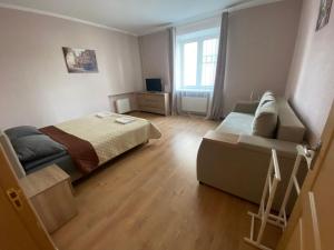 a small bedroom with a bed and a couch at Апартаменты на проспекте in Vinnytsya
