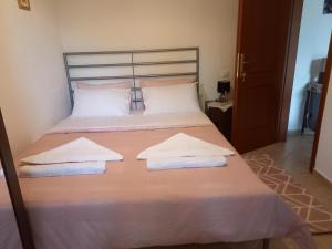 een slaapkamer met een bed met twee handdoeken erop bij ΠΗΛΙΟ- ΤΟ ΕΞΟΧΙΚΟ ΤΗΣ ΑΝΝΑΣ- ΑΦΗΣΣΟΣ in Afissos