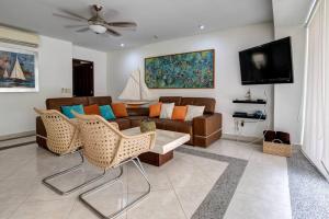 ein Wohnzimmer mit einem Sofa und einem TV in der Unterkunft Villa Magna departamento en Nuevo Vallarta in Nuevo Vallarta