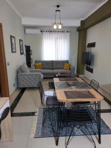 een woonkamer met een tafel en een bank bij Vila Tafa apartments ap3 in Tirana