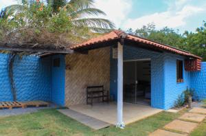 een blauw huis met een rieten dak bij Pousada Viva Barra in Barra Grande