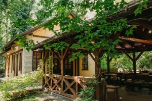 ein Haus mit einem Holzzaun und einem Baum in der Unterkunft Forest House in Palić