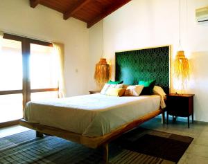 a bedroom with a large bed with a green headboard at Mendiolaza valle del sol in Mendiolaza