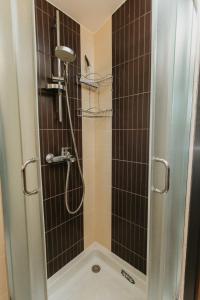 um chuveiro com uma porta de vidro na casa de banho em Forest House em Palić