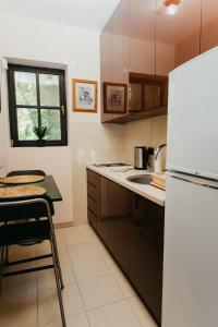 cocina con nevera blanca y fregadero en Forest House en Palić