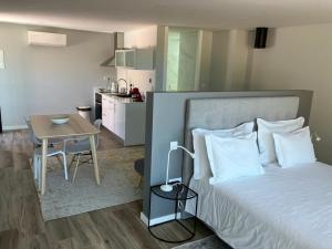 a bedroom with a bed and a table and a kitchen at DouroXisto in Peso da Régua