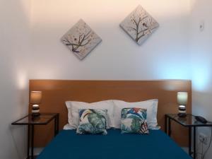 a bedroom with a blue bed with two pillows at Largo da Fonte in Sertã