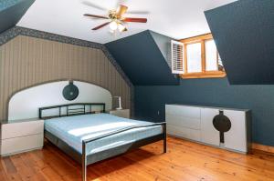 1 dormitorio con 1 cama y ventilador de techo en Pine Springs Retreat with Hot Tub Steam Room Lake Kushog, en Algonquin Highlands