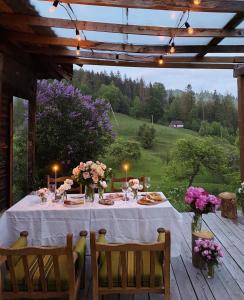 stół z kwiatami i świecami na drewnianym tarasie w obiekcie До Сонця Близько w Jaremczach