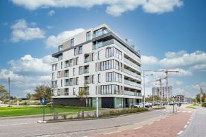 ein weißes Gebäude an der Straßenseite in der Unterkunft Duinenrij 197 in Bredene