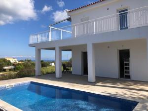a white house with a swimming pool in front of it at Villa Peony Koroni in Koroni