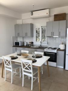 a kitchen with a white table and chairs in it at Villa Peony Koroni in Koroni