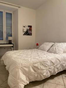 ein großes weißes Bett in einem weißen Schlafzimmer in der Unterkunft Le 12 Boulevard Paoli in Bastia