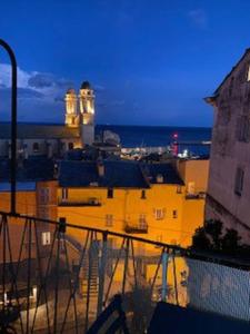 a view of a city at night with a lighthouse at Le 12 Boulevard Paoli in Bastia