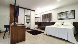 een hotelkamer met een bed, een bureau en een televisie bij Lindos Studios Centro/Wifi/Garagem in Foz do Iguaçu