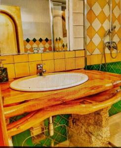 a bathroom with a sink on a wooden table with a mirror at Villa Smeralda in Olbia