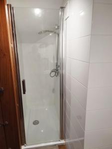 y baño con ducha y puerta de cristal. en Pokoje nad Młynem en Stryków