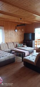 uma sala de estar com dois sofás e um piano em Chata z widokiem na Babią Górę em Pewel Wielka