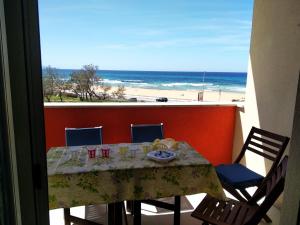 Una mesa en un balcón con vista a la playa. en Studio Flat Vista Mare, en Trapani