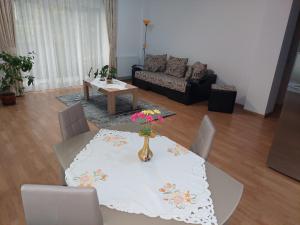 a living room with a table with a vase of flowers on it at Cosy apartment I in Târgu-Mureş