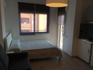 mały pokój z łóżkiem i 2 oknami w obiekcie Marbel 2 w Barcelonie