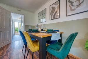 a dining room with a wooden table and blue chairs at 3 bedrooms, garden, free parking in Cirencester