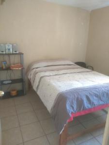 1 dormitorio pequeño con 1 cama y suelo de baldosa en Casa Valle Dorado SJR Fam, en San Juan del Río