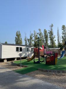 un parc avec une aire de jeux avec un toboggan et une remorque dans l'établissement Little John, à Fréjus