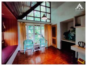 a living room with chairs and a table and a window at Grand Mulia Sakinah Resort & Outbond in Pasuruan