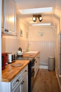 a kitchen with white cabinets and a wooden floor at Creran Apartment, Kinlochlaich House in Appin