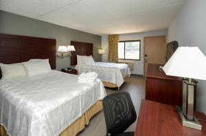 um quarto de hotel com duas camas e uma cadeira em Americas Best Value Inn at Central Valley em Central Valley