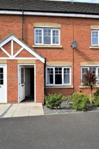 a red brick house with a white door at Cosy 3 bedroomed home on 3 floors in Darlington