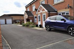 a blue car parked in front of a house at Cosy 3 bedroomed home on 3 floors in Darlington