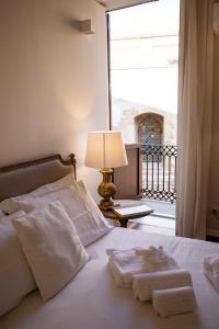 a bedroom with a bed with towels and a lamp at Dimora Sinibaldi in Palermo