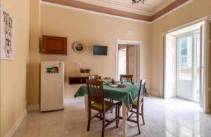 a kitchen and dining room with a table and a refrigerator at A Casa ra Signurina in Modica