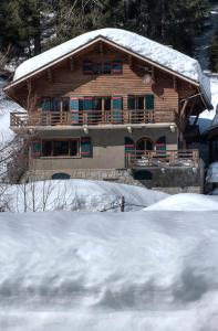 una casa in legno con neve sul tetto di La Ribambelle a Chamonix-Mont-Blanc