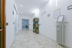 a hallway with white walls and a tile floor at Alle Porte Del Centro - Guest House - Reggio Emilia - Ingresso Centro Storico - Parcheggio Gratuito in Reggio Emilia