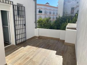 Habitación vacía con balcón con vistas a un edificio en Precioso apartamento con patio/terraza Zona centro, en Jerez de la Frontera