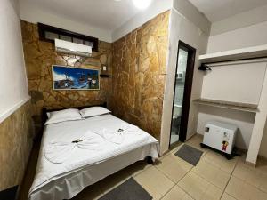 um quarto com uma cama e uma parede de pedra em Pousada Ilha Grande em Abraão