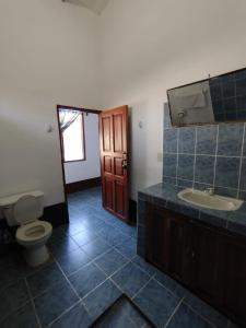 ein Badezimmer mit einem WC, einem Waschbecken und einem Spiegel in der Unterkunft El Curichal Hostel in Rurrenabaque