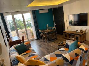 マルティーグにあるLE PARADIS APPARTEMENTのソファとテーブル、テレビのあるリビングルーム