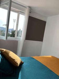 マルティーグにあるLE PARADIS APPARTEMENTの大きな窓のあるベッドのある寝室
