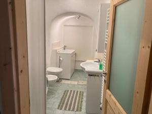 uma casa de banho branca com um WC e um lavatório em CASA DIAF appartamento incantevole Carano Ville di Fiemme em Carano