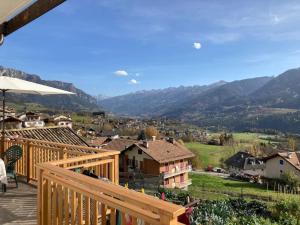 a wooden deck with a view of a village at CASA DIAF appartamento incantevole Carano Ville di Fiemme in Carano