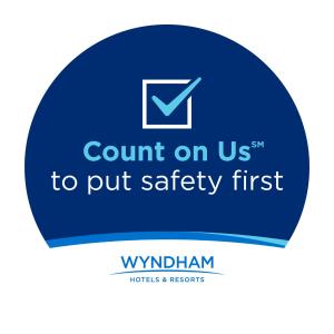 a sign that says court on us to put safety first at Days Inn by Wyndham Dallas Irving in Irving