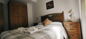 - une chambre avec un lit et des serviettes dans l'établissement Alojamientos Puerta del Parque, à Cazorla
