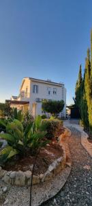 un grand bâtiment blanc avec des plantes devant lui dans l'établissement Fab Sea and Mountain View Villa, walking distance from the Sandy Beach, à Yialia