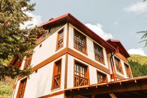 una casa con ventanas de madera en un lateral en İSKALİTA Otel en Altındere