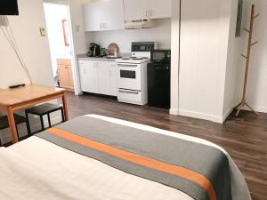 a room with a bed and a kitchen with a stove at Duncan Motel in Duncan